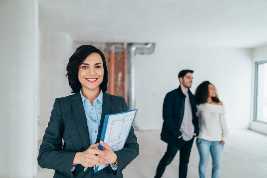 Realtor smiling with homebuyers and real estate home warranty