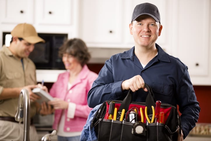 Contractor smiling with bag of home repair tools after completing work order