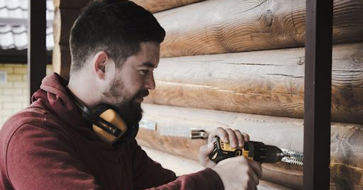 Man using cordless drill to install home appliance