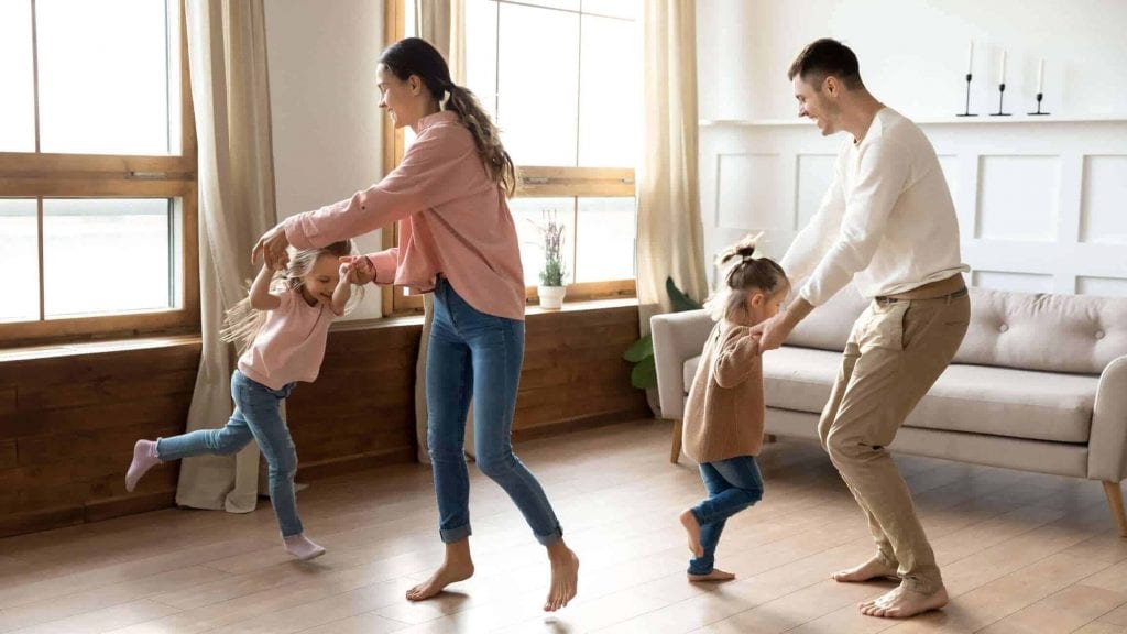 Family dancing in living room with peace of mind from home warranty coverage