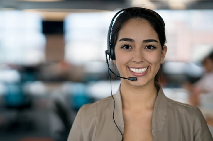 Smiling customer service representative speaking on the phone with homeowner who needs appliance repair