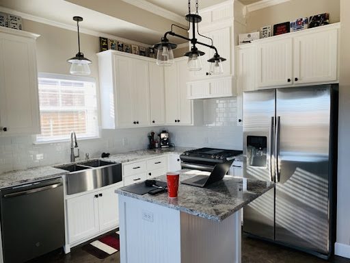 stainless steel fridge in large, open kitchen